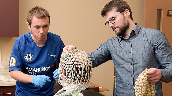 Photo of professor mentoring students in cognitive lab.